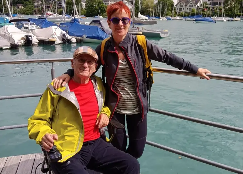 Una pareja, él usuario de silla de ruedas, en un mirador de un lago de Suiza