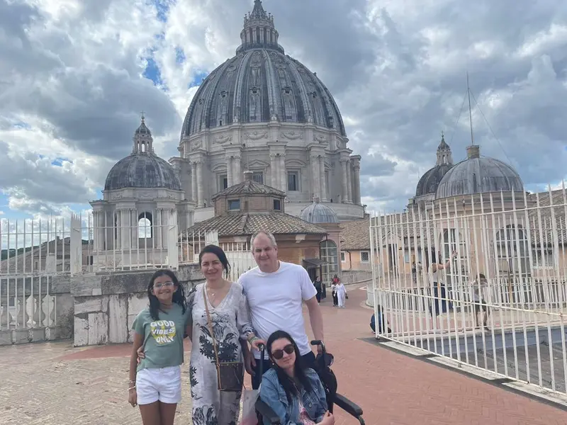 Una familia de viaje por Europa con la cúpula de Sacre Coeur de fondo