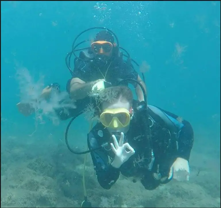 La foto muestra a una persona con discapacidad realizando buceo adaptado junto a su pareja